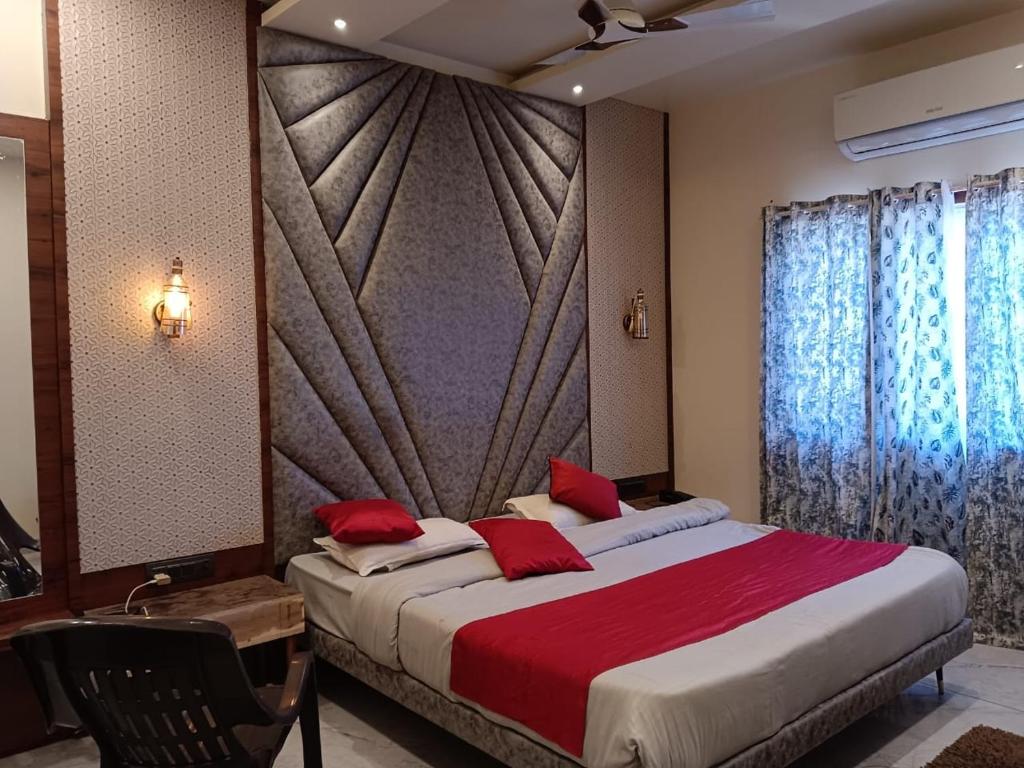 伯杰默里Hotel satpura inn的卧室里有一张大床，配有红色枕头