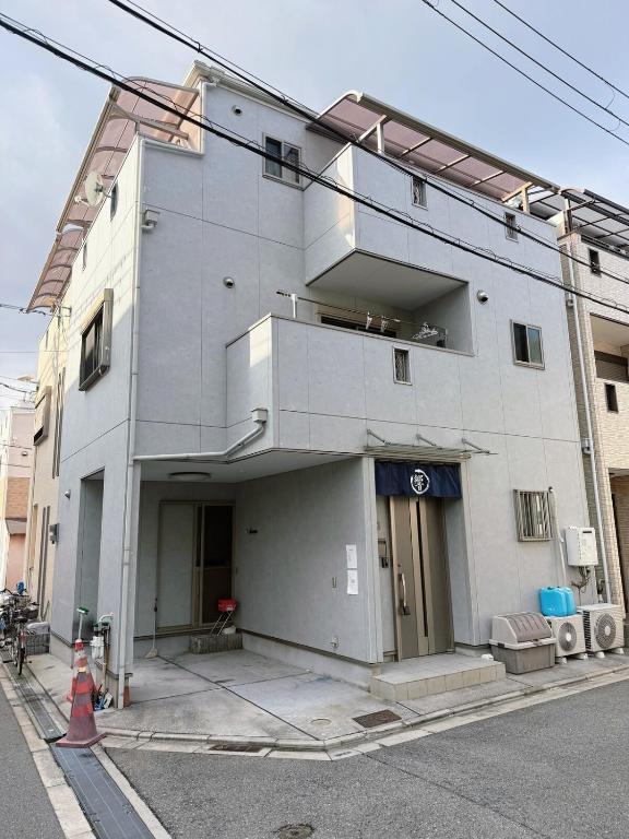 a large white building on the corner of a street at hibiki hotel osaka in Osaka
