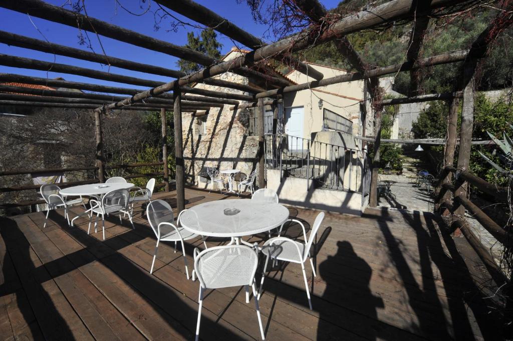 due tavoli e sedie su una terrazza di legno di Agriturismo La Contessa a Finale Ligure