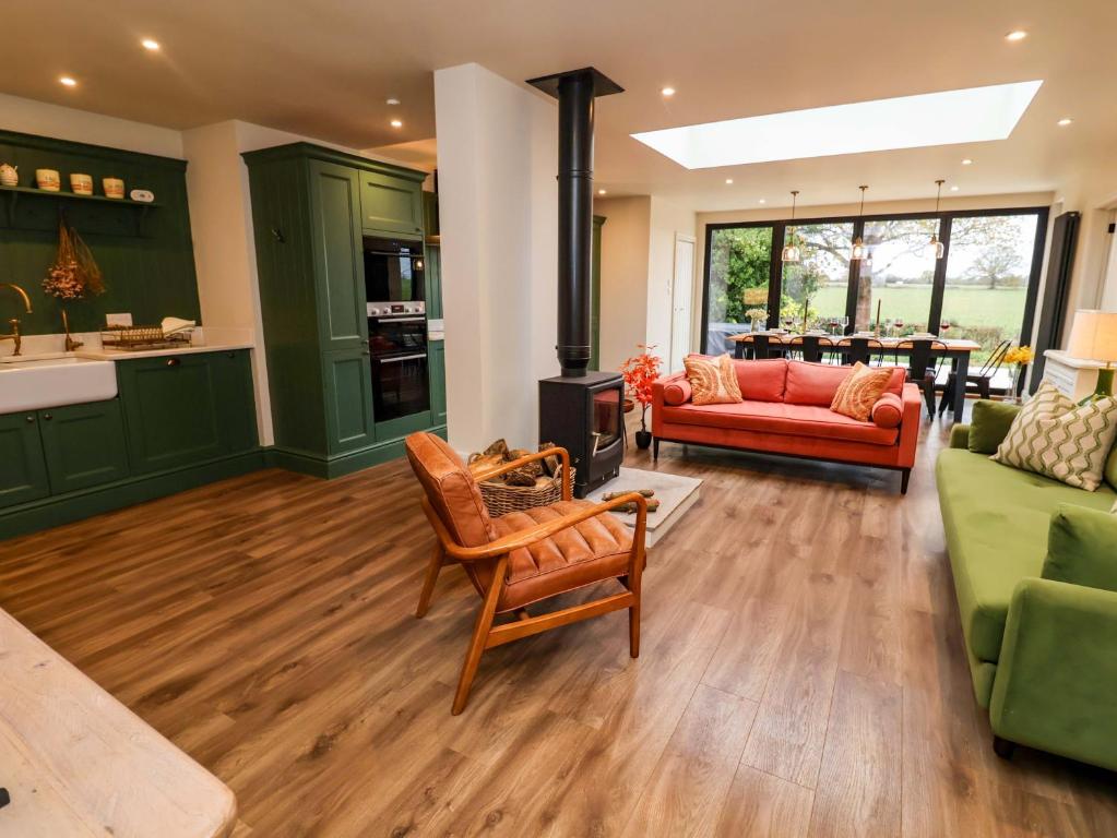 a living room with green cabinets and a stove at Fairview in Saxmundham