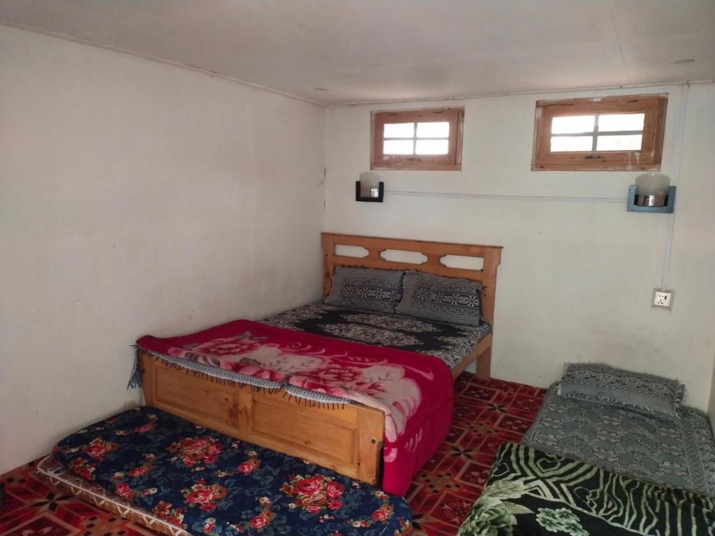 una camera da letto con due letti e due finestre di Kalash Resort and camping side a Chitral