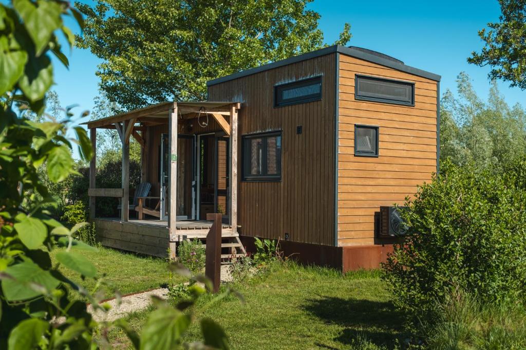 una piccola casa in un giardino con un capanno di Tiny Greenhouse op Boetiekpark de Kas a Scherpenzeel
