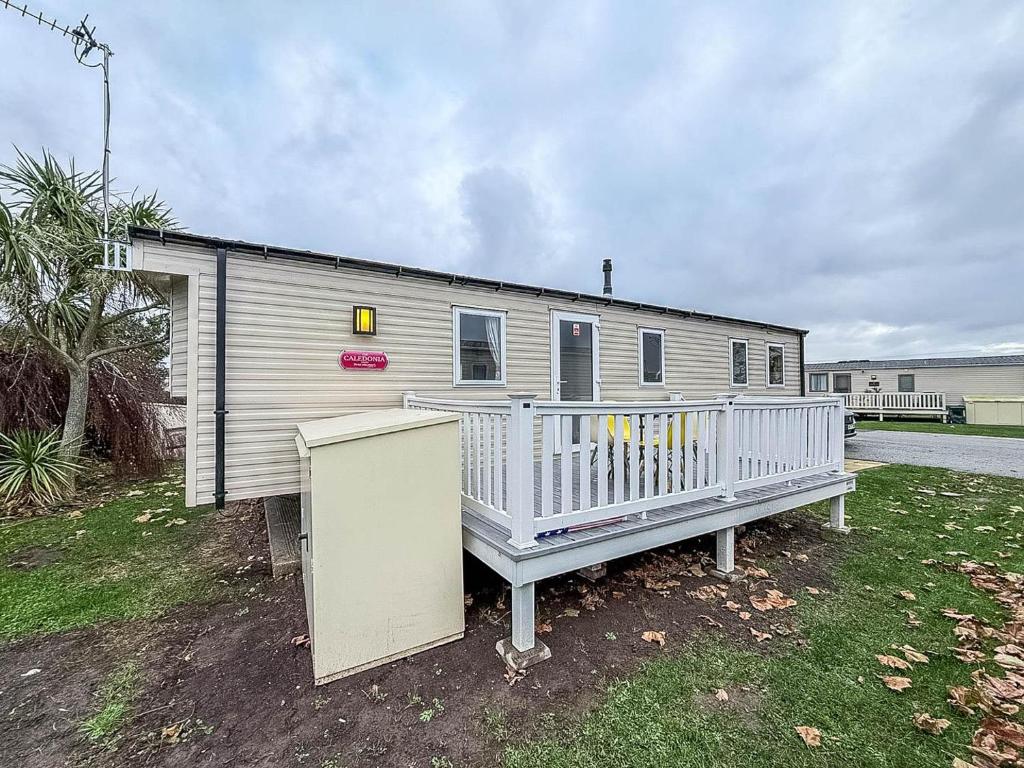 a mobile home with a porch and a house at Great 8 Berth Caravan For Hire At Seawick Holiday Park In Essex Ref 27227Sw in Clacton-on-Sea