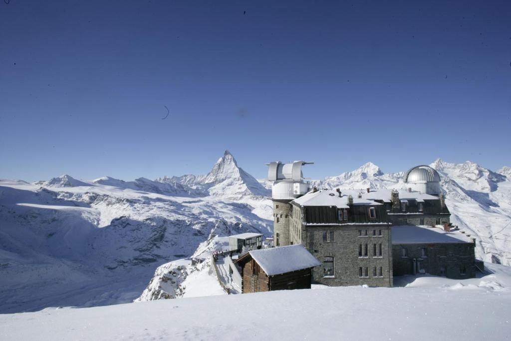 a snow covered mountain with a snowboard on top of it at 3100 Kulmhotel Gornergrat in Zermatt