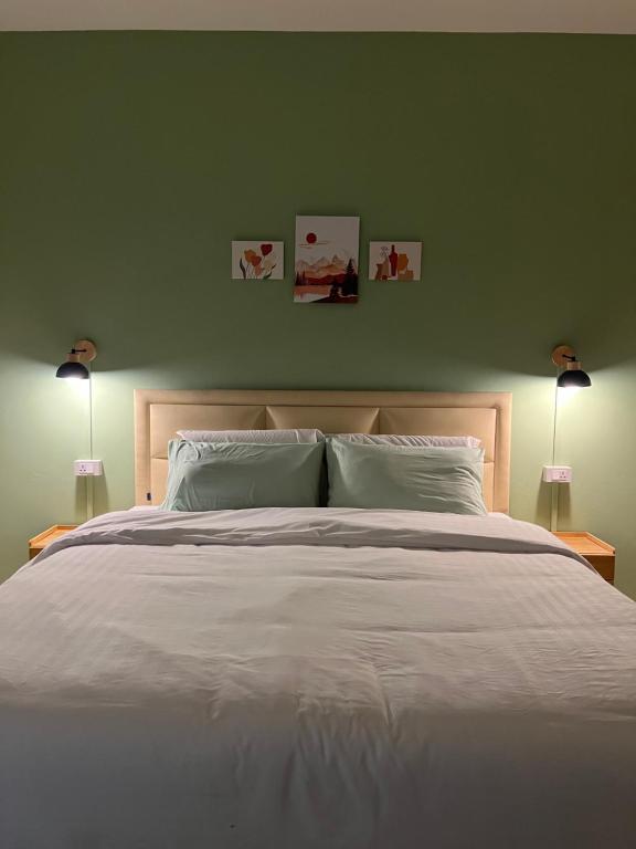 a bedroom with a large white bed with two lamps at Calm Stay & Cafe in Chiang Mai