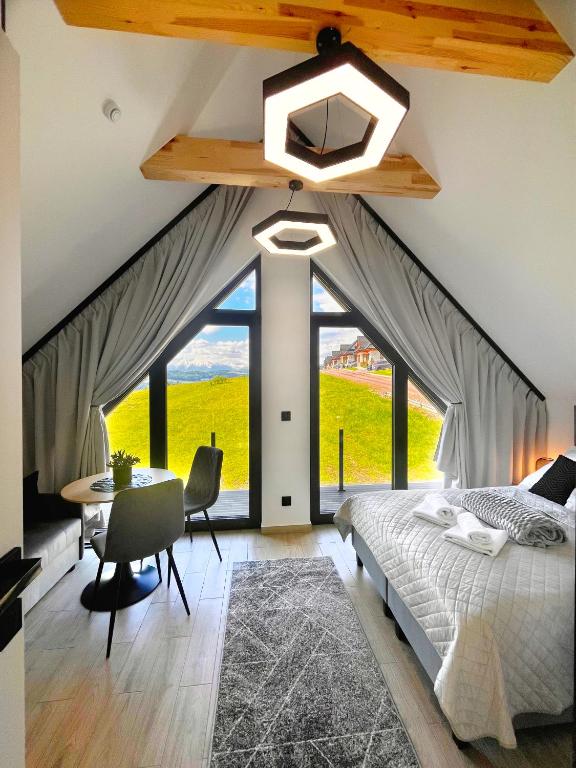 a bedroom with a large bed and a table and chairs at Willa Pienińska 123 in Maniowy