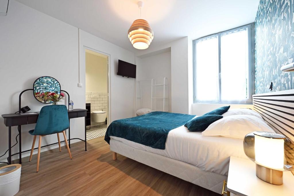 um quarto branco com uma cama e uma secretária. em Hôtel le Terminus et son restaurant Côte à Côte - Chambres rénovées em Autun