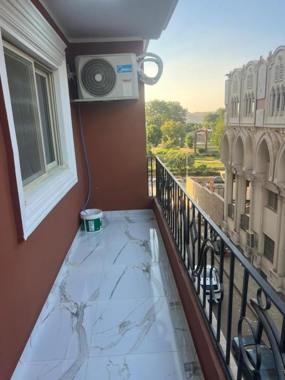 a balcony with a glass table and a window at Aswan in Nag` el-Ramla