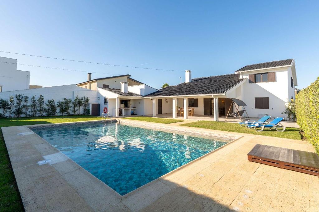 une piscine devant une maison dans l'établissement Ma-la Beach House by HostWise, à Marinhas