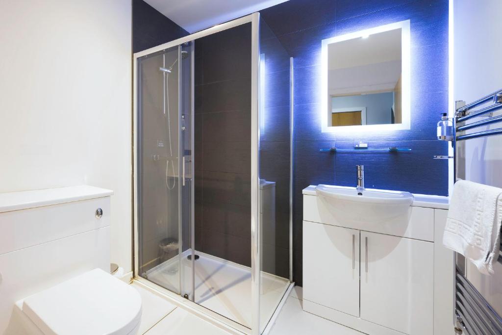 a bathroom with a shower and a toilet and a sink at Crown Hotel & Bar in Inverness