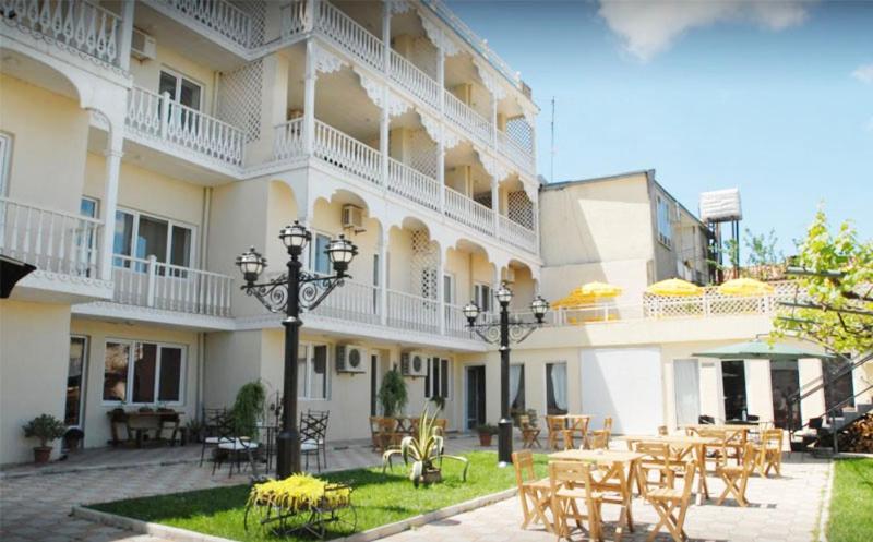 Un hotel con mesas y sillas en un patio en Hotel Old Marani, en Itʼkhvisi