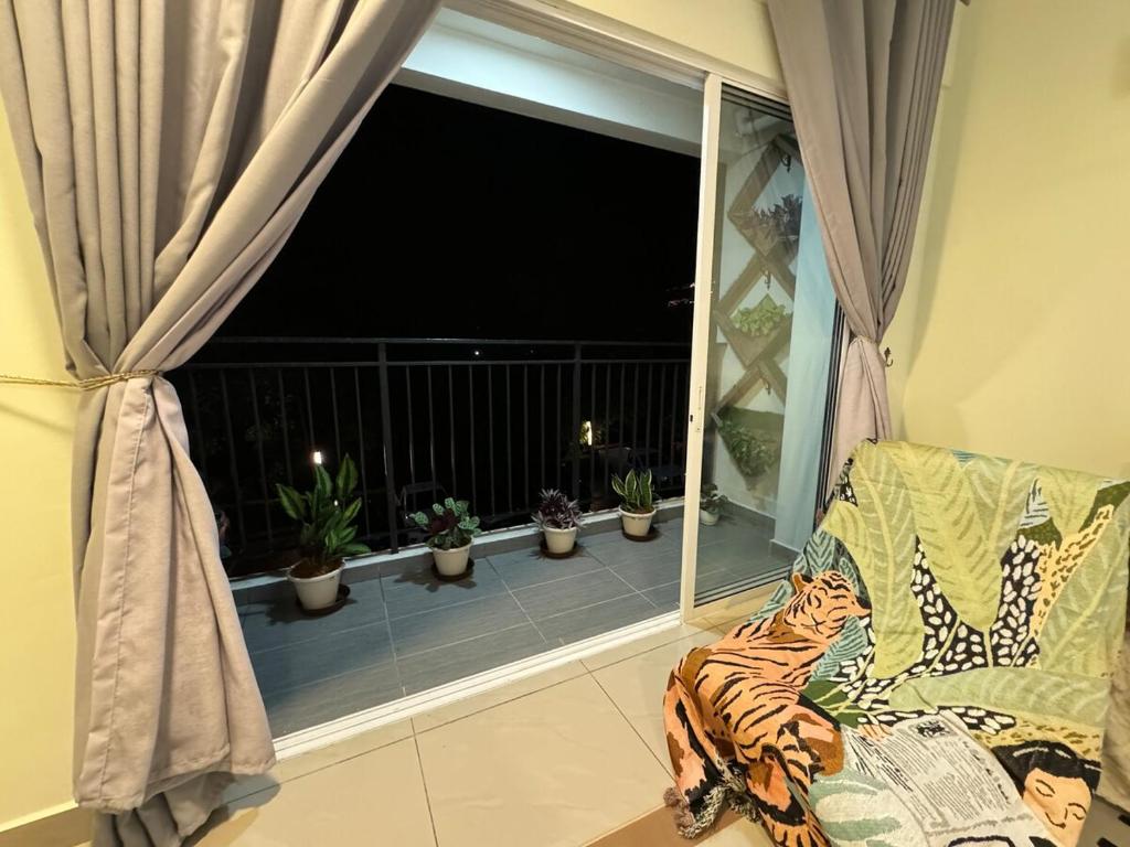 a room with a couch and a window with plants at Tea Valley & Farm View at Cool Summer Cameron in Cameron Highlands