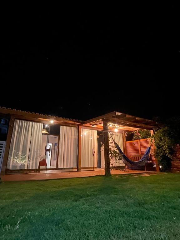 een huis met een hangmat in de tuin 's nachts bij casa celeste in Imbituba