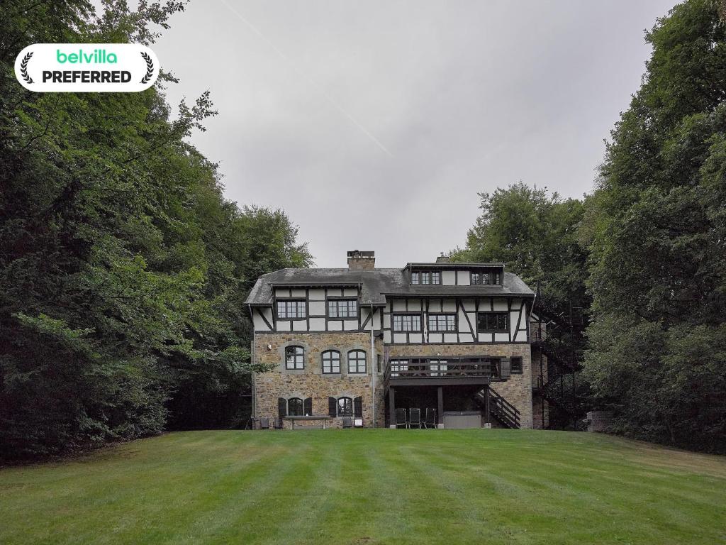 een groot stenen huis met een groot grasveld bij Spacious Villa in Liège in Spa