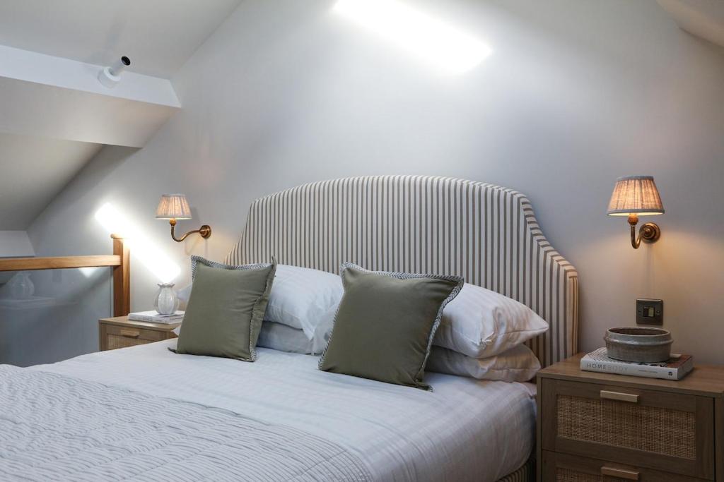 a bedroom with a white bed with two lamps and two tables at Luxury Apartment in Shropshire sleeps 4 in Shrewsbury