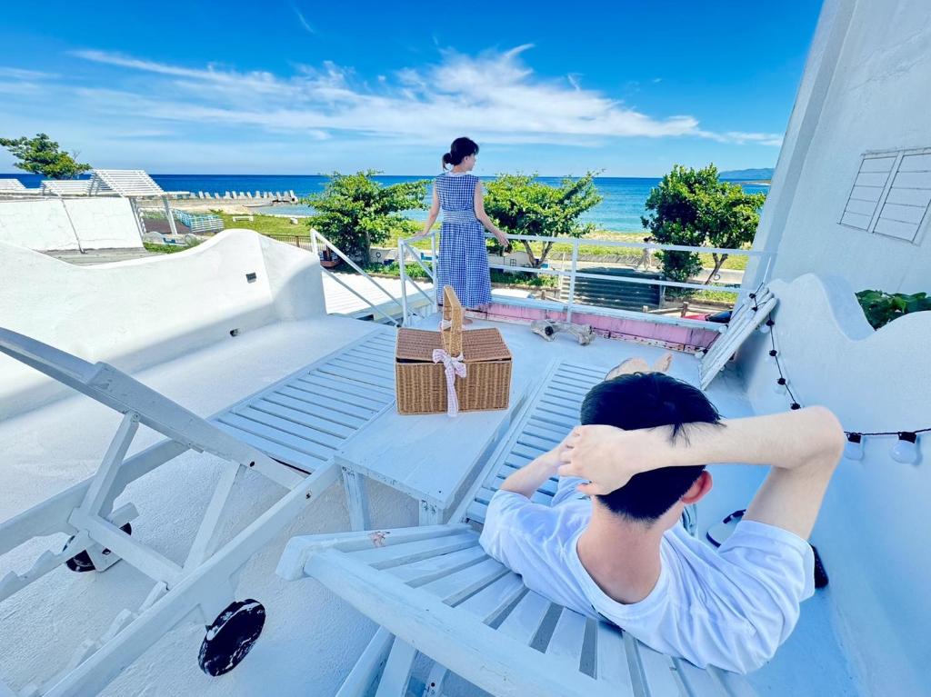 una donna è seduta su una panchina del bagnino su una spiaggia di Whitiedoggie Villa II a Checheng