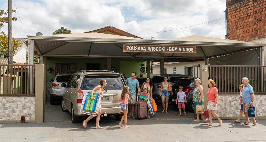 a group of people standing outside of a car garage at Pousada Wisocki in Matinhos