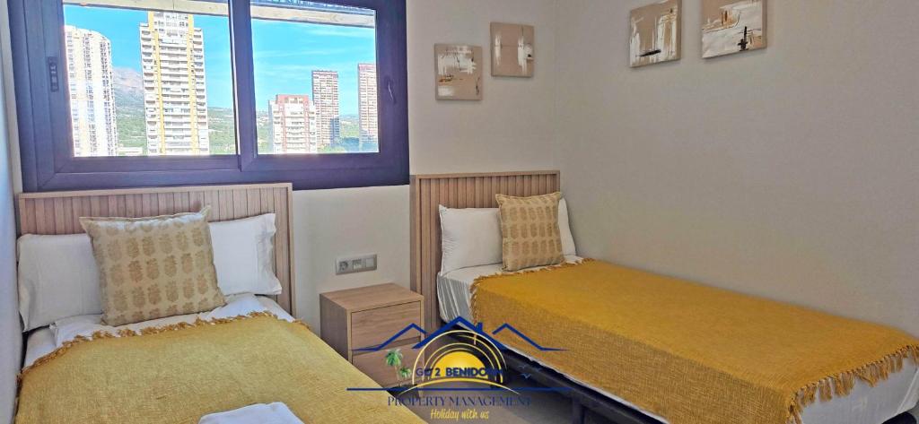 een kamer met twee bedden en een raam bij Nini Sunset Sailor Luxury Apartment in Benidorm