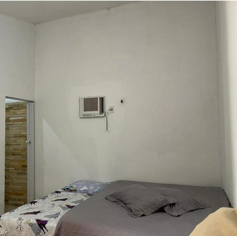 ein Schlafzimmer mit einem Bett und einer Klimaanlage an der Wand in der Unterkunft Pousada Pé na Areia Morro Branco in Beberibe