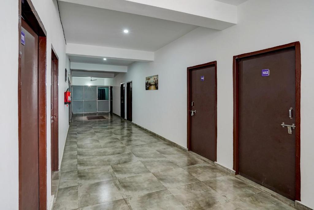 un couloir vide avec deux portes et du carrelage dans l'établissement Super Hotel O Omi Rooms, à Gurgaon
