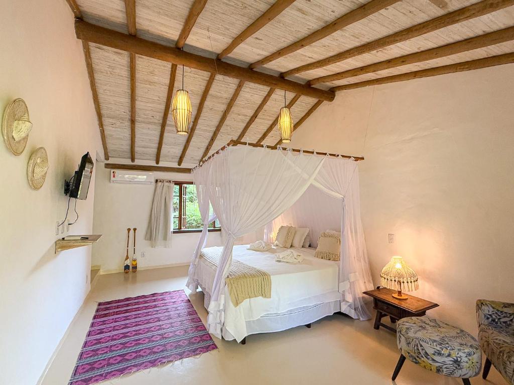 un dormitorio con una cama con mosquitera en Pousada Hibisco, en Trancoso