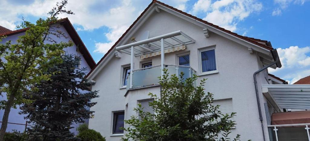 a white house with a balcony on the side of it at Ferienwohnung in Baunatal in Baunatal