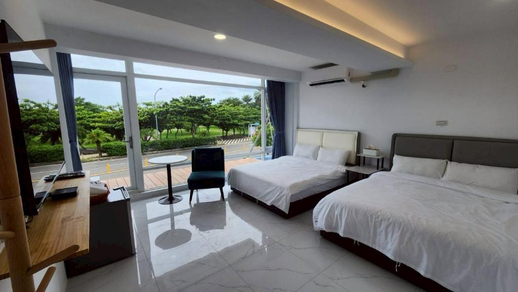 a bedroom with two beds and a view of a street at 南灣沐洋168民宿 in Hengchun