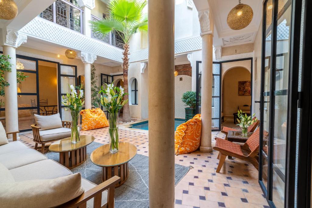 een lobby met banken en tafels en een zwembad bij Riad Beldi in Marrakesh