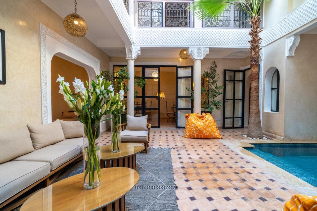 a living room with a couch and a swimming pool at Riad Beldi in Marrakesh