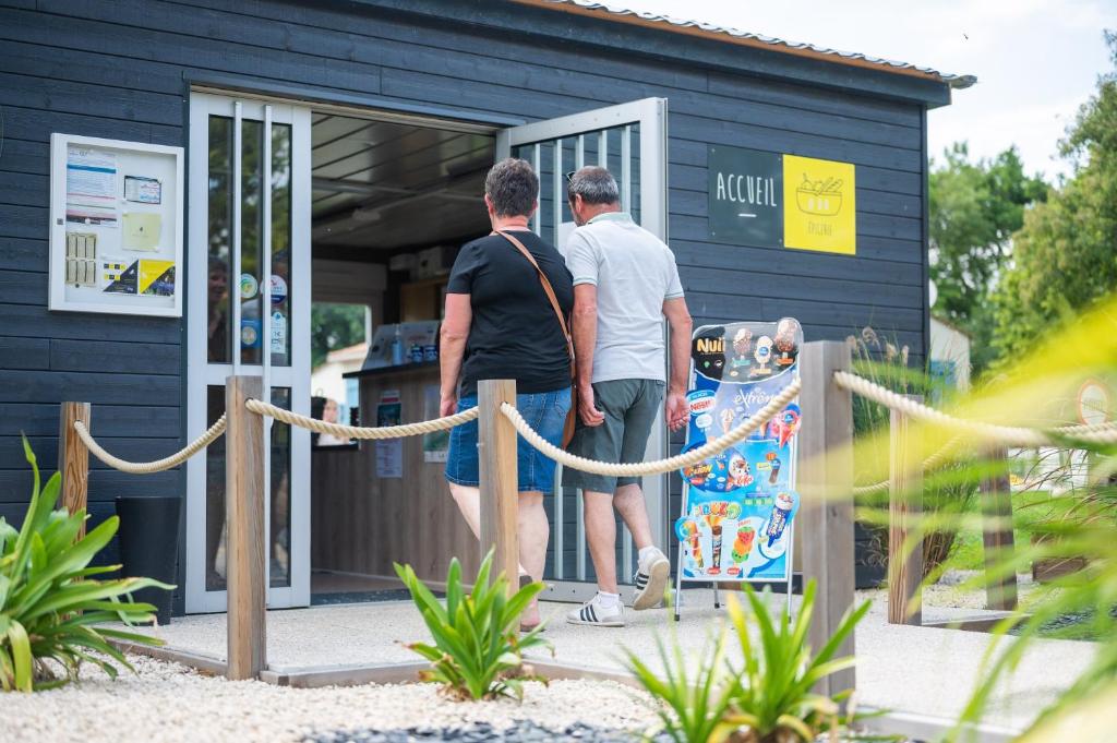 Twee mannen staan buiten een gebouw. bij Mobilehome riviera avec terrasse 23 in Saint-Gervais