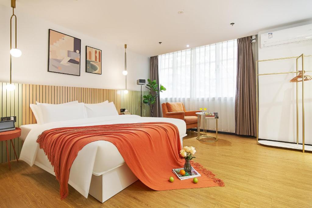 una camera da letto con un letto grande con una coperta rossa di LIU YUAN Amoy Smart Hotel 厦门留苑智能酒店 a Xiamen