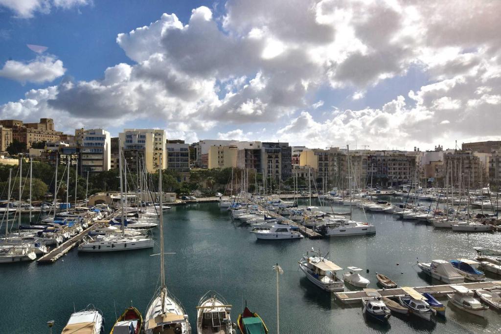 un gruppo di barche attraccate in un porto con edifici di Bright and Central 2 Bedroom with Harbour view a Msida