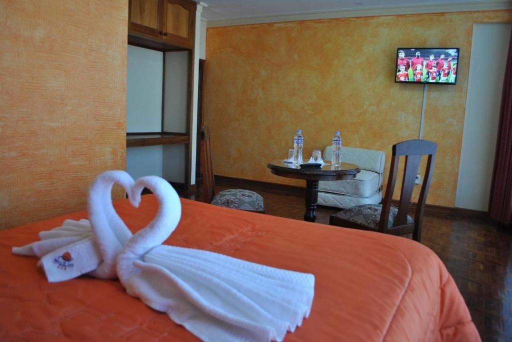 2 cigni fatti di asciugamani su un letto di Hotel Perla del Lago a Copacabana