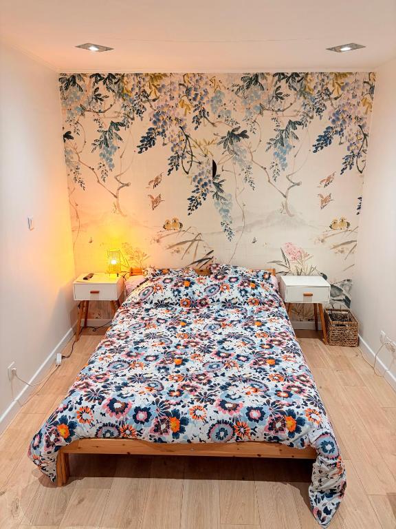 a bedroom with a bed and a floral wall at Coin de paradis à Grenoble in Poisat