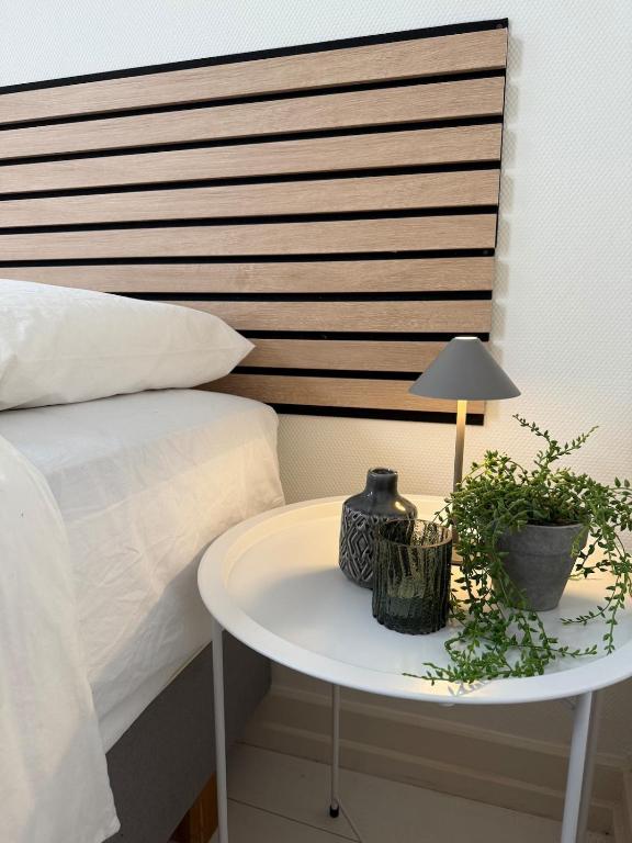 a bedside table with a lamp and plants on it at 't Zusje in Enschede