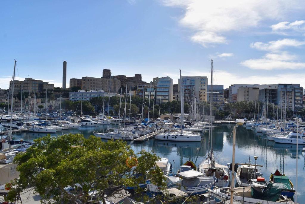 a bunch of boats docked in a harbor with a city at Sea view Spacious 2 bedroom central apartment in Msida