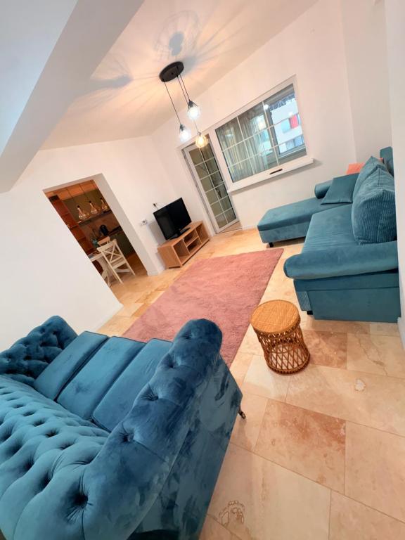 ein Wohnzimmer mit einem blauen Sofa und einem Tisch in der Unterkunft Ultracentral 1 Craiova in Craiova