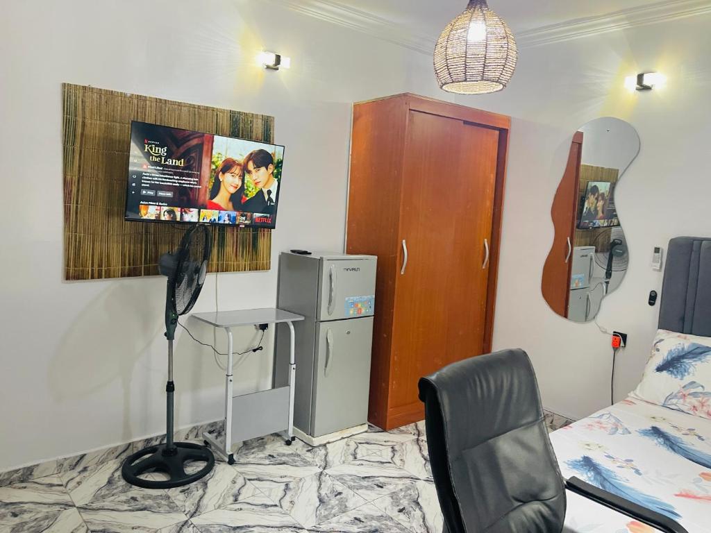 een kamer met een bed en een bureau en een bed en een kamer bij Private Studio Apartment in Lagos