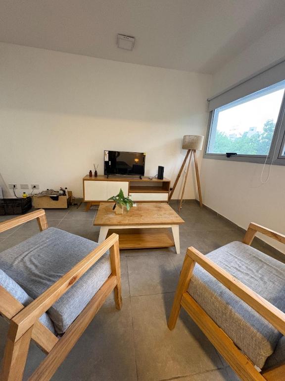 拉普拉塔Departamento monoambiente La plata, Zona centro的有两张床和一张桌子的客厅