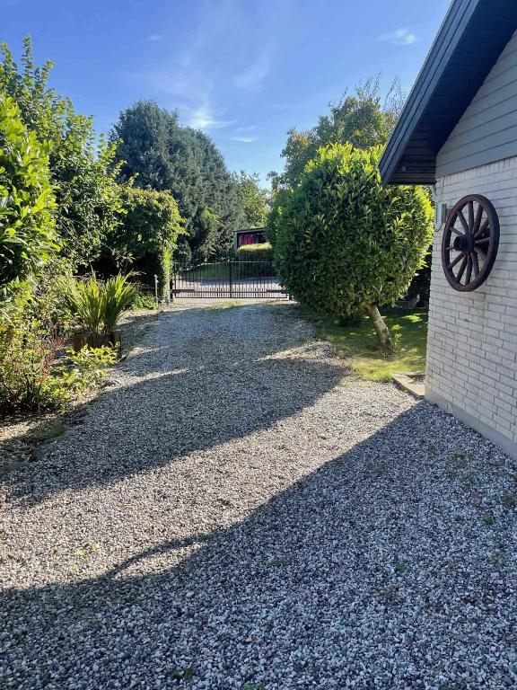 SkambyCozy Holiday Home On North Funen的一条石子车道,旁边是一座带围栏的房子