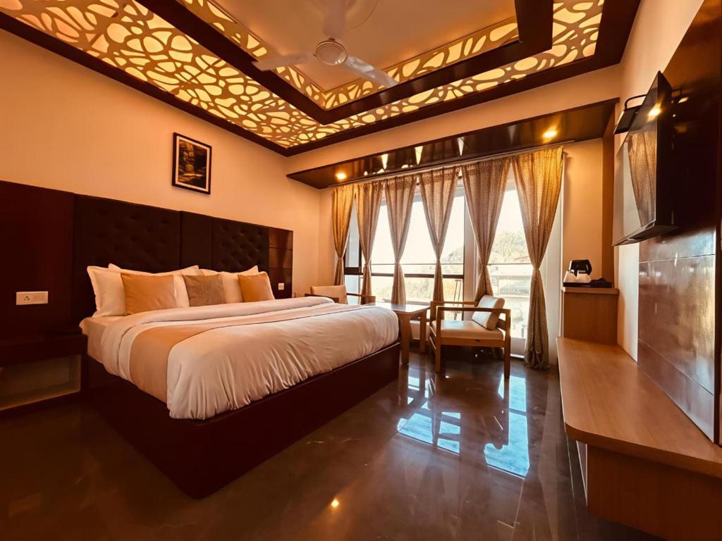 a bedroom with a large bed and a large window at The Grand Dwaper Walking Distance From Mall Road in Mussoorie