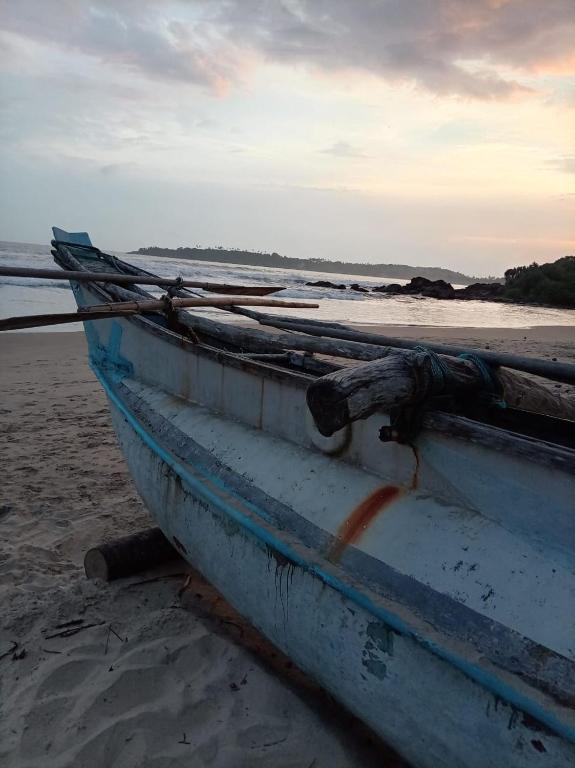 a boat sitting on the beach near the water at White shell in Sinimodera