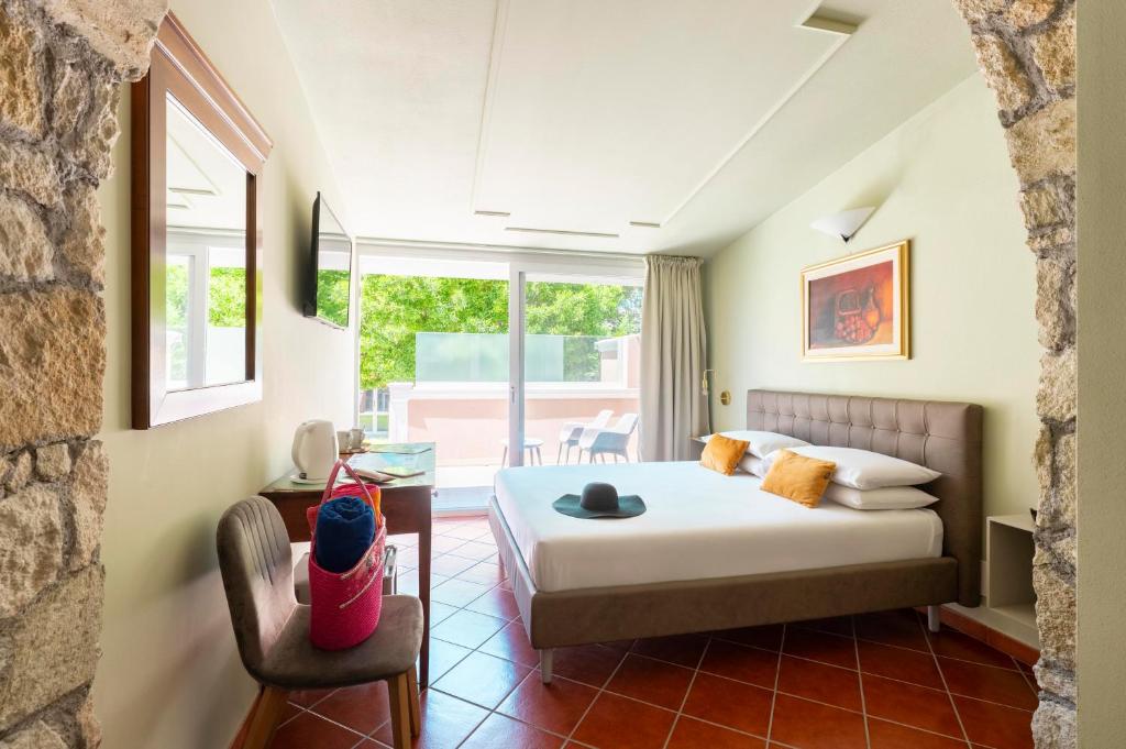 ein Schlafzimmer mit einem Bett, einem Stuhl und einem Fenster in der Unterkunft Dimore Morelli Amantea in Amantea