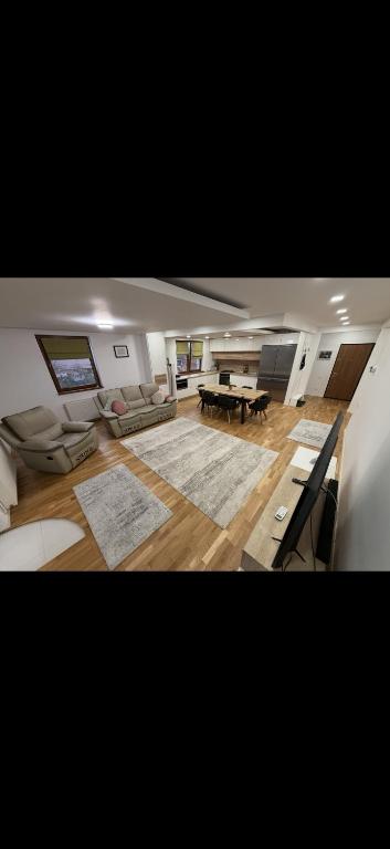 Una gran sala de estar con un sofá y una mesa. en Cozy Central Apartment 2, en Sighetu Marmaţiei