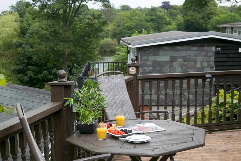 einem Holztisch mit einem Obstteller auf dem Deck in der Unterkunft Comfortable 2 Bed Chalet near Snowdonia - Pass the Keys in Caeathro