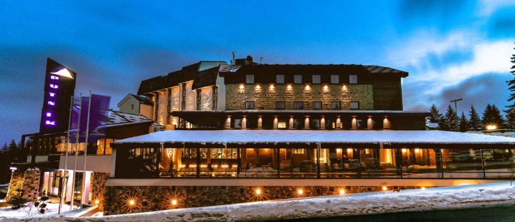 un edificio nella neve di notte di Hotel Putnik Kopaonik a Kopaonik