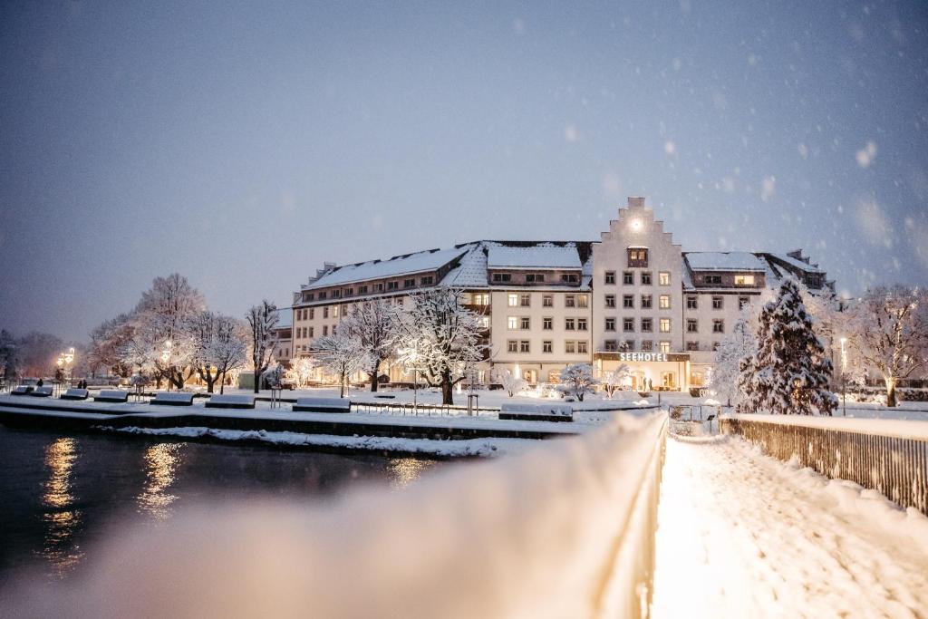 洛豪Seehotel am Kaiserstrand的一座被雪覆盖的建筑物,位于河边