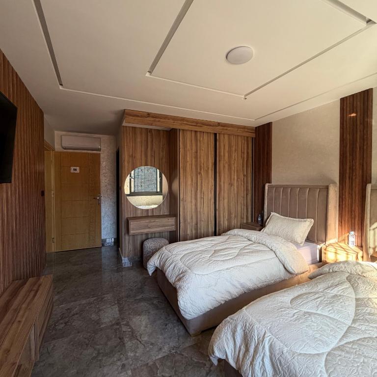 Un dormitorio con dos camas y un televisor. en Moul Partma Berkane N5, en Berkane