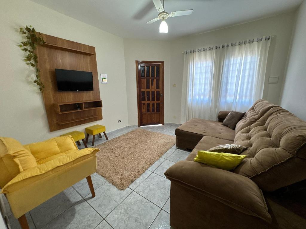 a living room with a couch and a tv at Casa completa, ar e vaga, perto parque Ecológico in Ourinhos