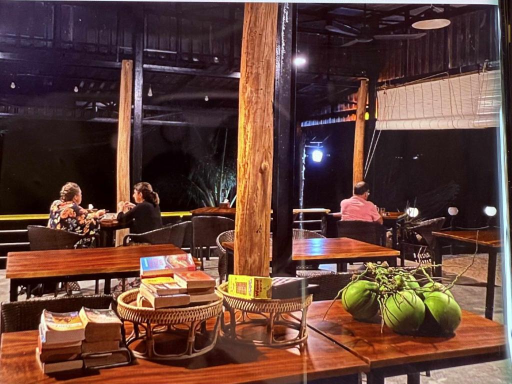 un grupo de personas sentadas en mesas en un restaurante en kohrong sweet beach bungalows, en Koh Rong
